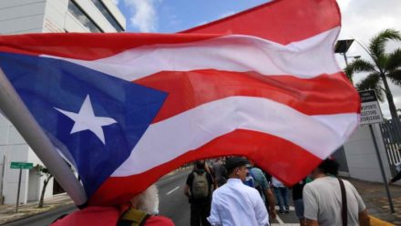 bandera puertorriqueña cargada por manifestante